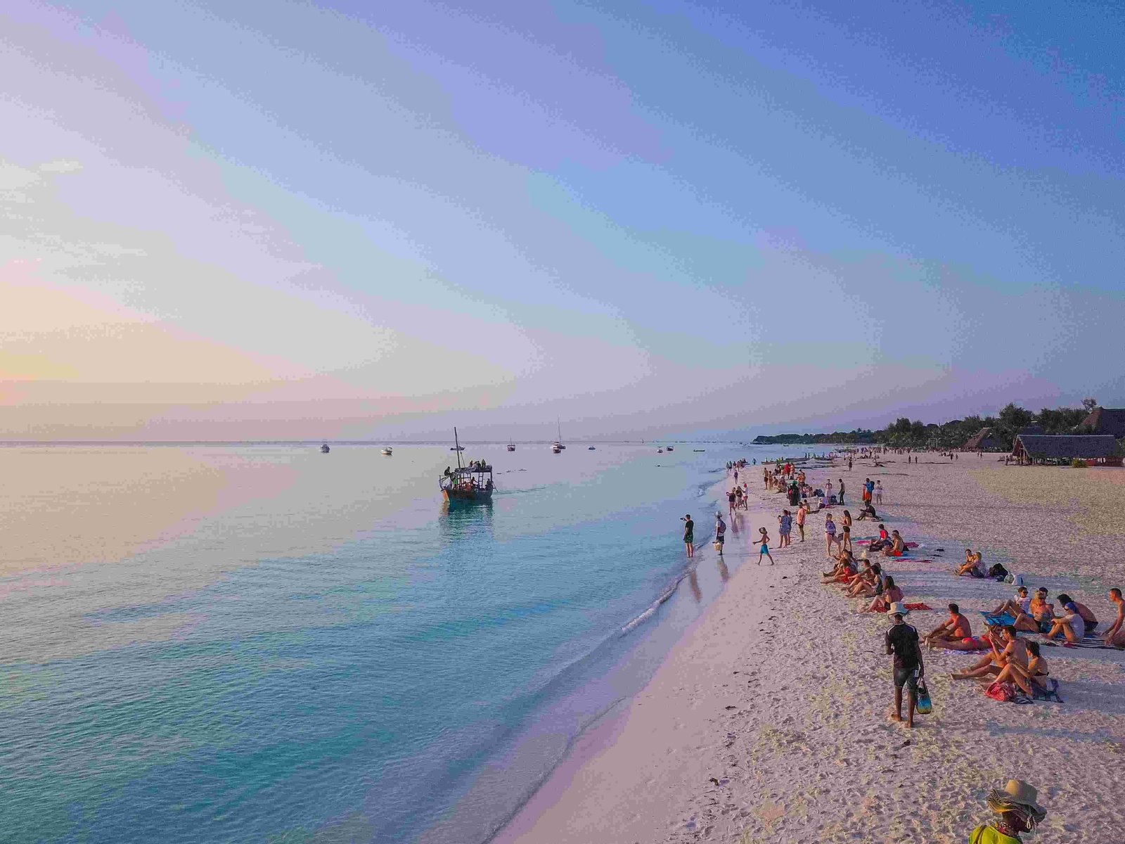 Zanzibar beach at golden hour with turquoise water and dhows