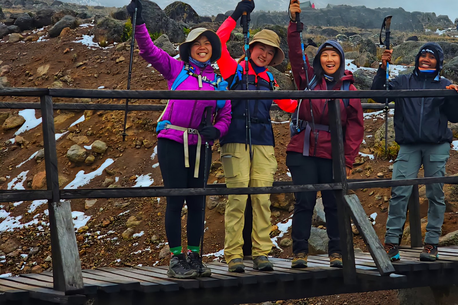 Climbers celebrating on a wooden bridge on Mount Kilimanjaro